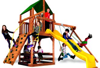 Children playing on a premium cedar wooden swing set in a landscaped backyard on a sunny day.